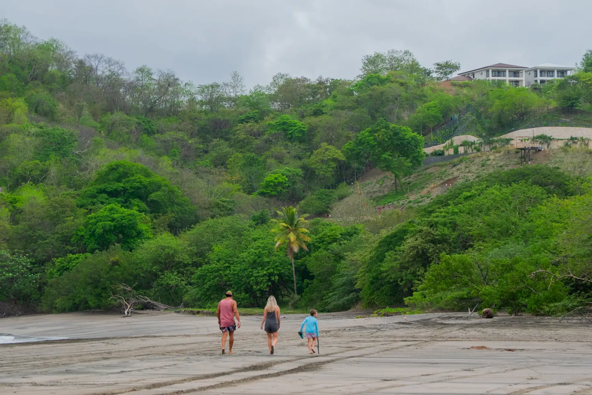 Family walking on Brasilito beach toward the treeline